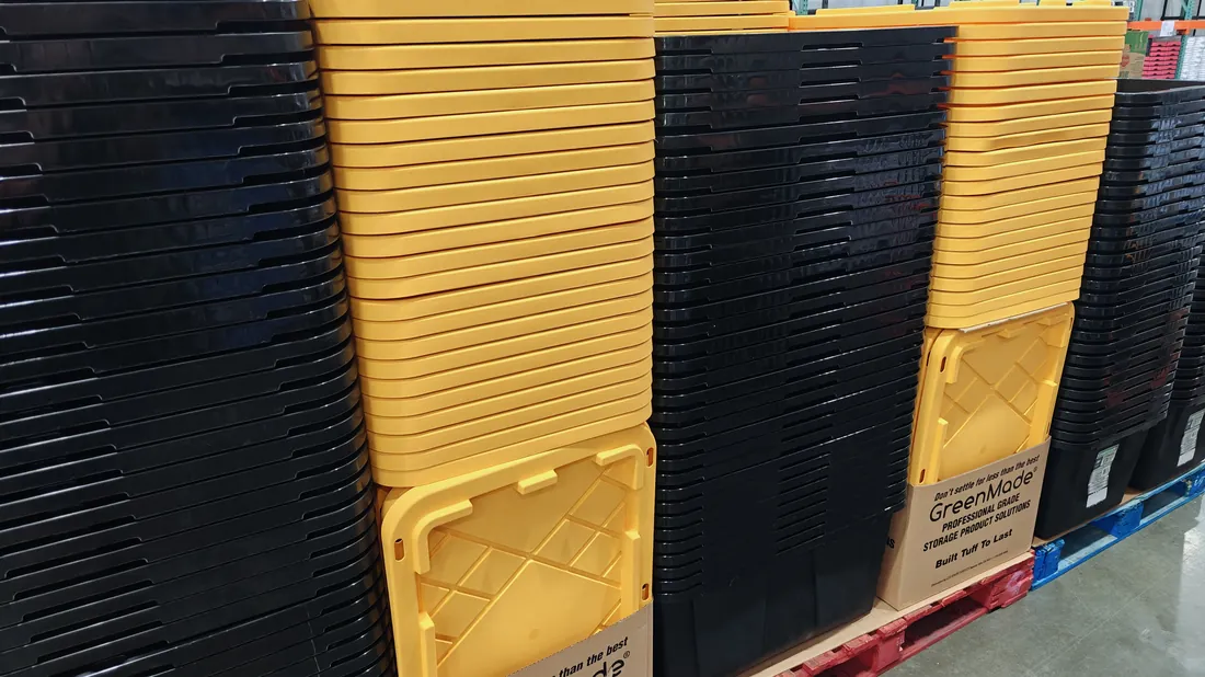 Pallets of black totes and yellow lids