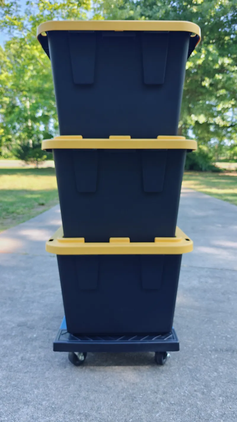 Side view of three stacked totes on a dolly